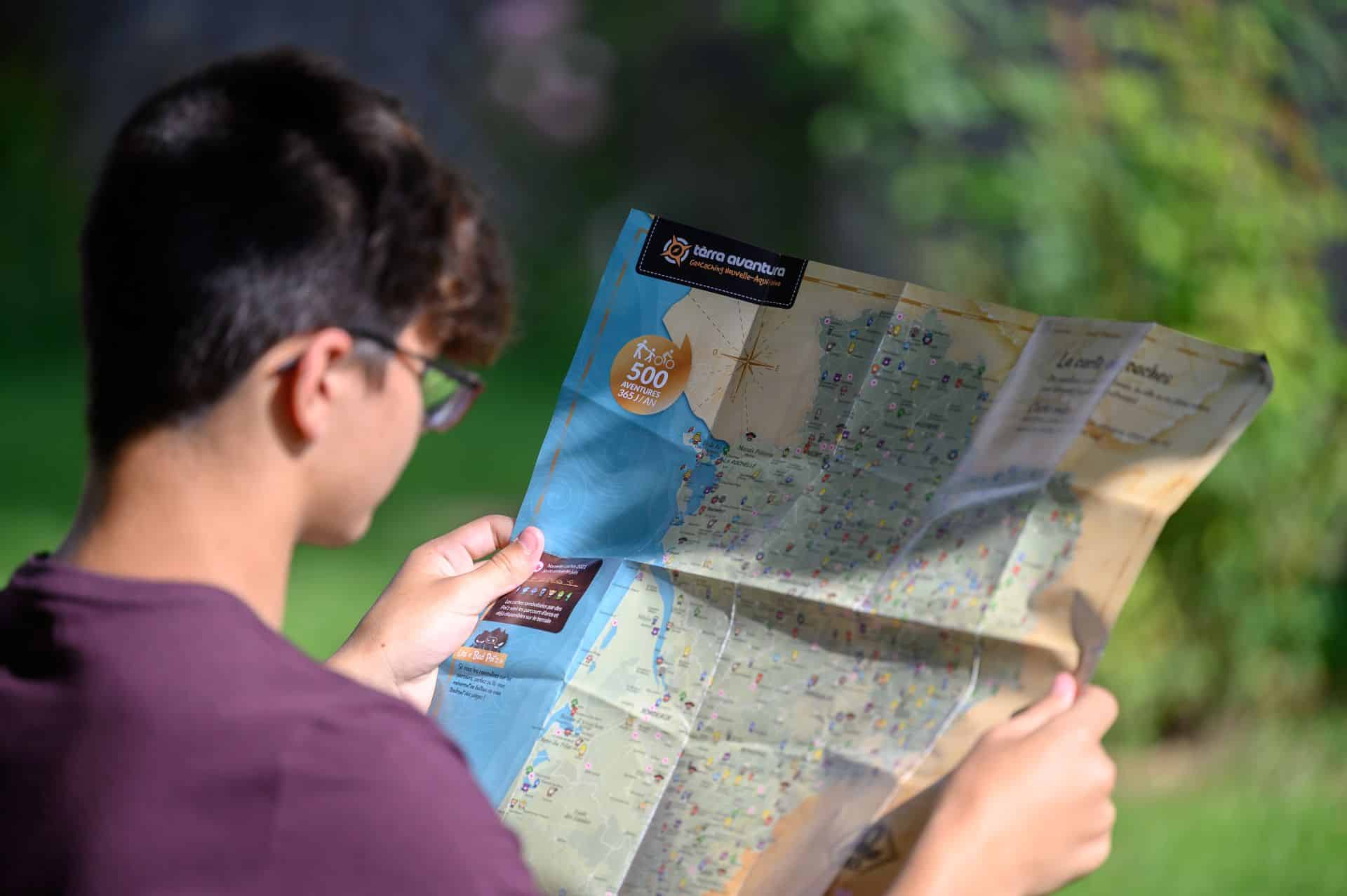 Jeune homme qui regarde la carte Tèrra Avetura